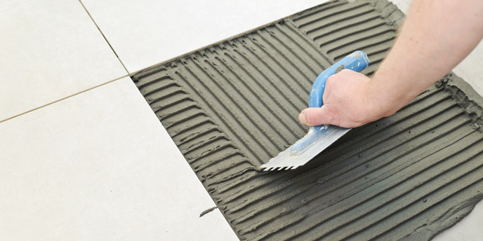 Hand Smoothing Tile Grout on Floor