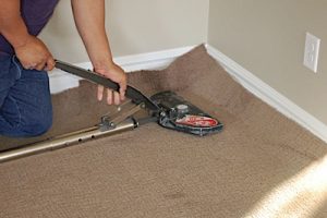 Using a stretcher to install carpet.