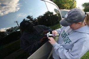 AMUS volunteer making a VIN etching.