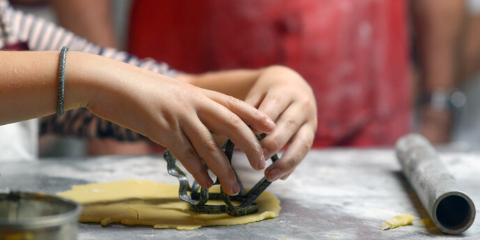 Two Figures Cutting Out Holiday Cookies