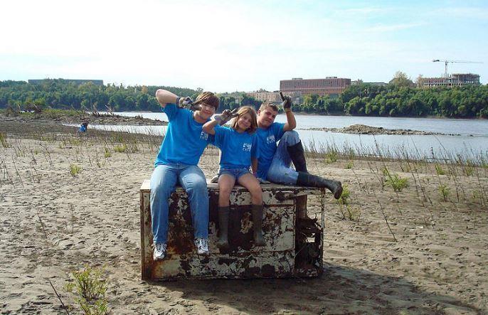 Three child volunteers for a river cleanup event.