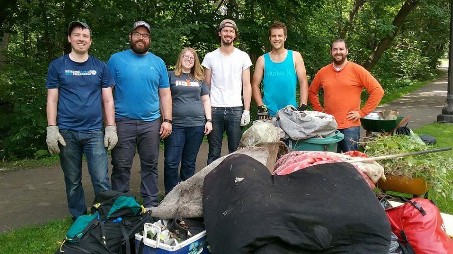 People posing with a pile of trash after a group volunteer activity.