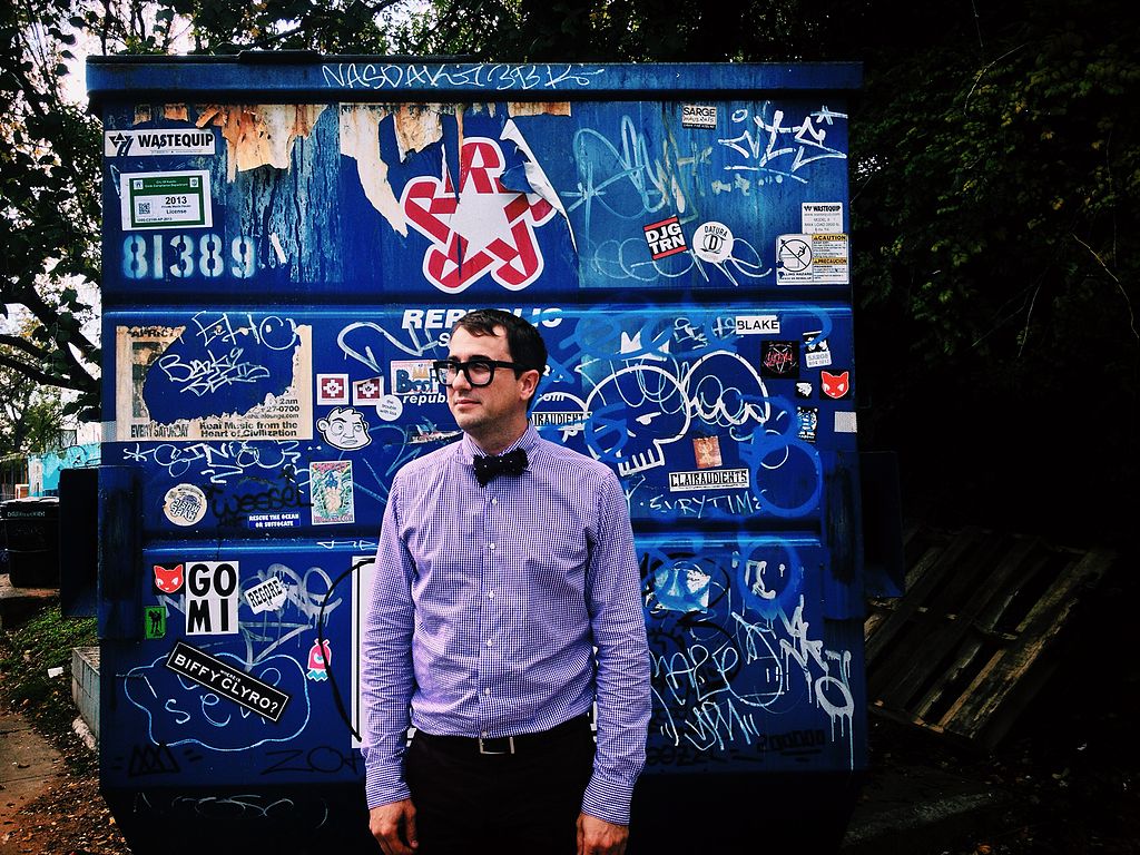 Professor Jeff Wilson posing in front of his literal home away from home. Image: “Professor Dumpster” by Jeff Wilson, CC by 3.0