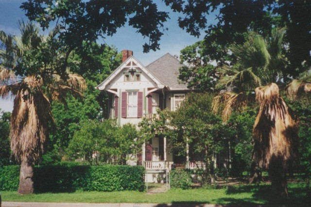 A historic home in Austin hidden by trees.