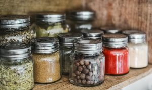 Glass Jars Filled With Spices Inside a Cupboard.