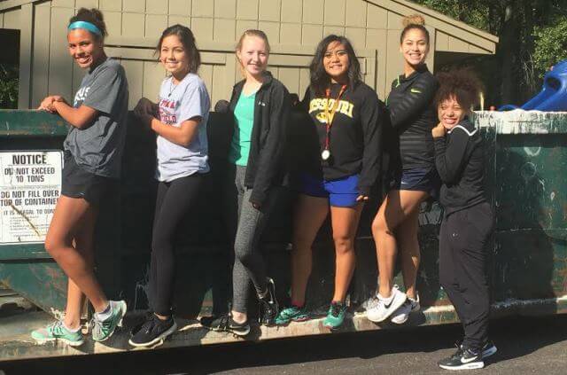 Girls Posing in Front of Donated Dumpster