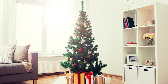 Artificial Christmas Tree in a Bright Living Room Next to Couch and Shelves