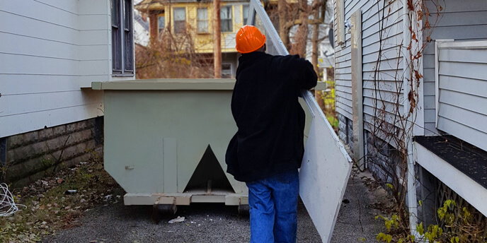 Man Throwing Trash in Dumpster