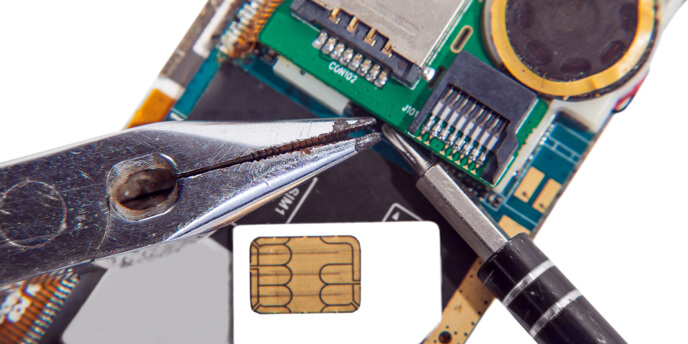 Close-up of Cellphone Interior With Pliers and Screwdriver in Foreground