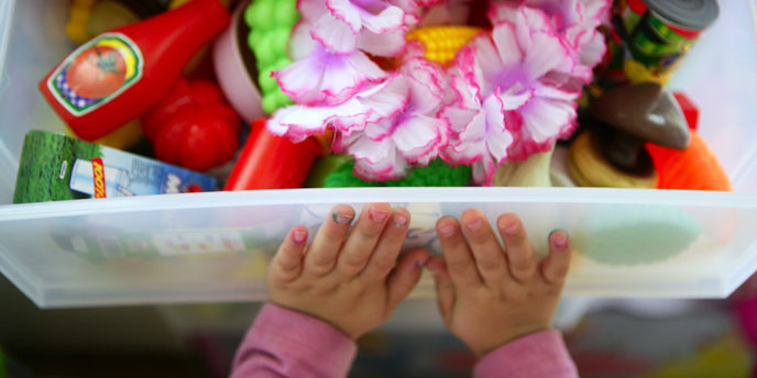 Child’s Hands Closing Toy Bin Organizer Filled With Children’s Toys