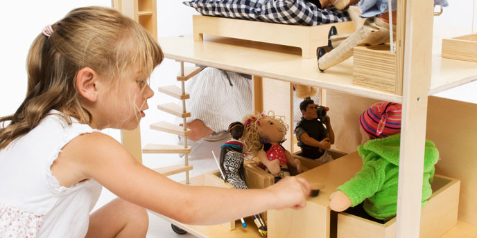 Young Girl Playing with Dolls In Wooden Doll House