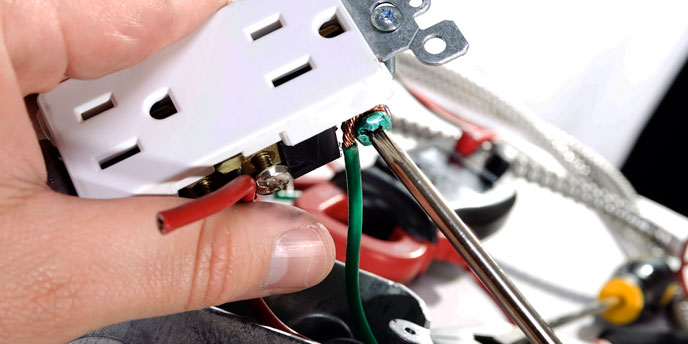 Hand Installing Electrical Outlet With Screwdriver