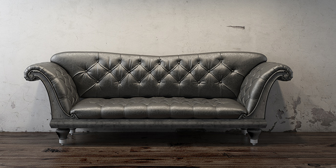 Black Couch In Front Of Dingy Grey Wall