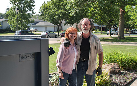 Couple Standing Beside a Dumpster in a Neighborhood