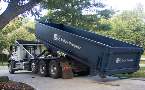 Truck Delivering a Roll Off Dumpster in a Driveway