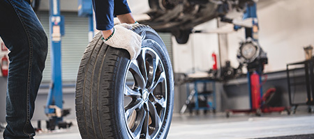 Person Holding a Tire in a Garage