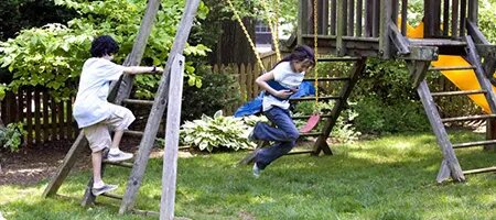 Children Playing on Wooden Swingset