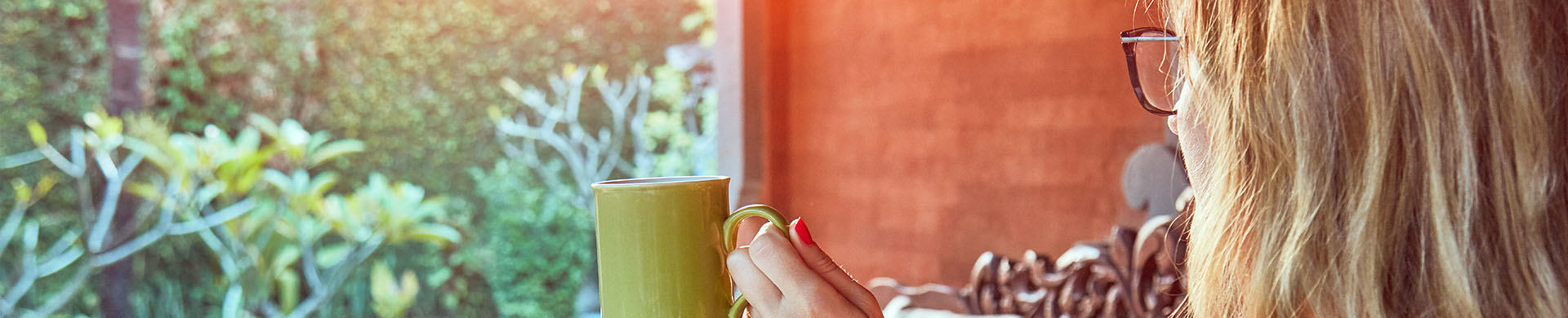 Woman Sitting With Coffee in Backyard