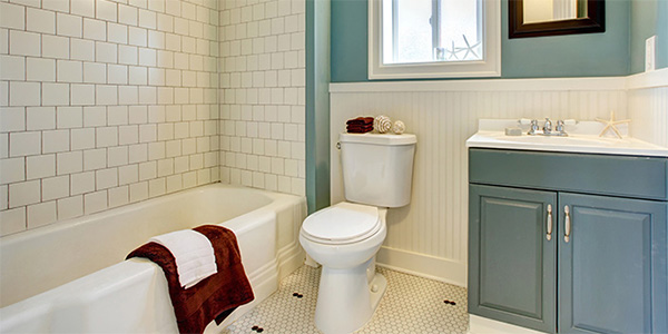 Remodeled Bathroom With White Tile Floor and Shower and Blue Vanity