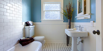 Small Blue Bathroom With White Tile and Sink