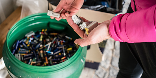 Woman Disposing of Batteries at Recycling Center