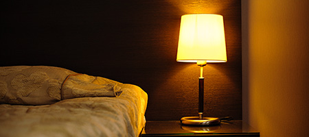 Dimly Lit Bedroom With Bedside Lamp