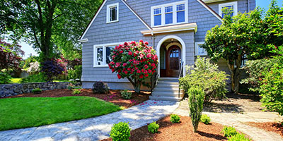 Blue House With Trees and Front Lawn