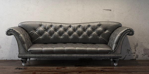 Black Couch In Front Of Dingy Grey Wall