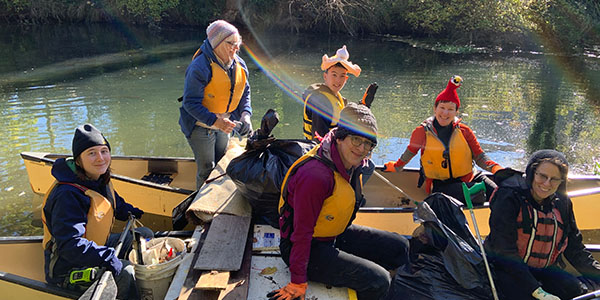 Volunteers in Boat Gathered at River Bank