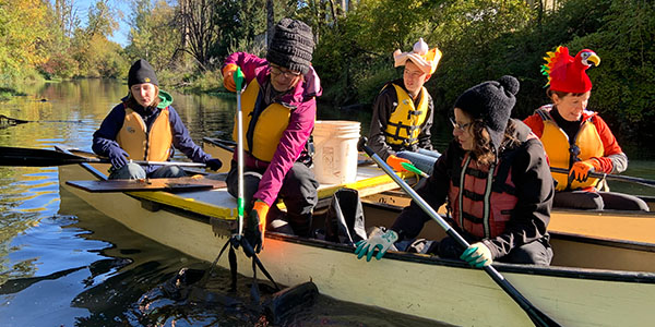 Volunteers in Boat Picking Trash From Waterway