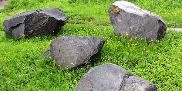 Two Large Boulders Next to Paver Stones in Yard