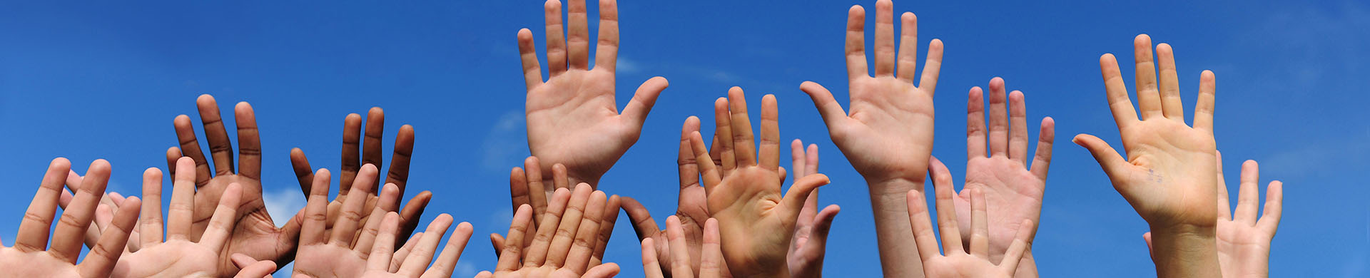 Group of Raised Hands Against a Blue Sky
