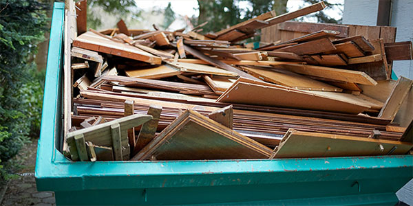 Green Dumpster Filled With Cabinet Debris