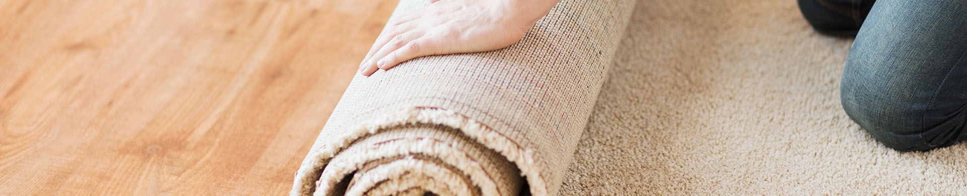 Person Rolling Up Beige Carpet