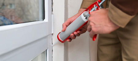 Man Using Caulk Gun to Seal Windows