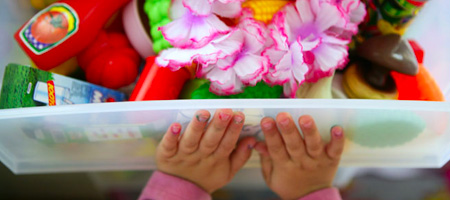 Child’s Hands Closing Toy Bin Organizer Filled With Children’s Toys