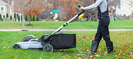Woman Uses Lawn Mower With Bag to Mulch and Collect Leaves