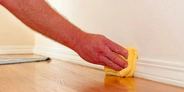 Hand Wiping Down a Baseboard