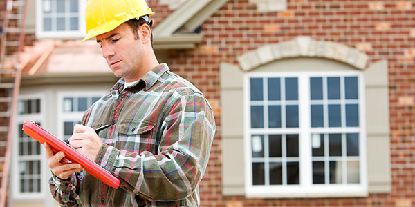 Contractor Wearing Hard Hat and Looking at Home Project Plans