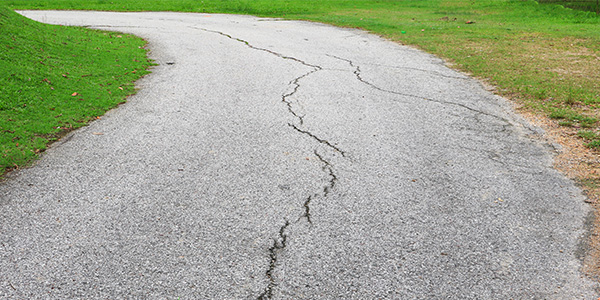 Cracked Driveway Curved Around Patch of Grass
