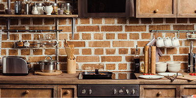 Brick Kitchen with White Pottery and Cluttered Countertops