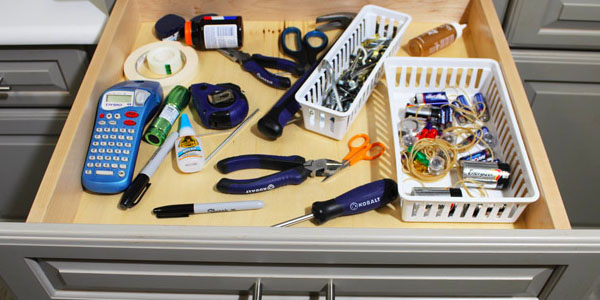 Disorganized Junk Drawer with Tools and Office Supplies