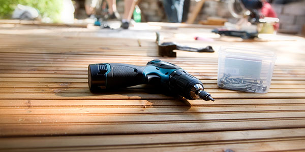 Drill and Nails Laying on Wood Deck Boards