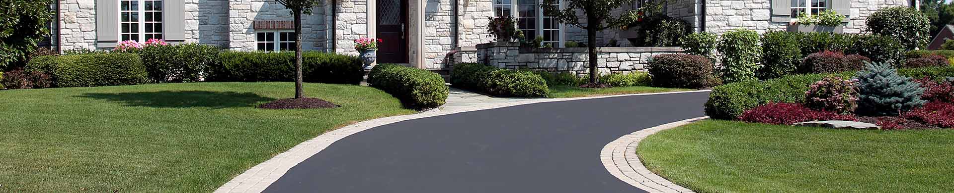 Paved Driveway in Front of White Stone House