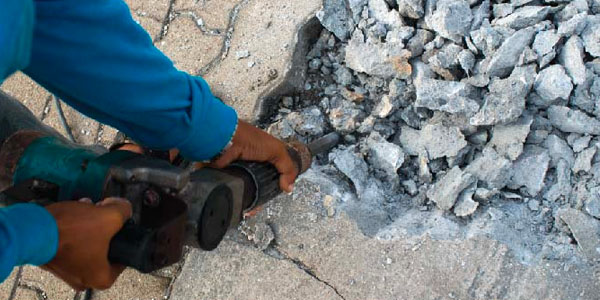 Man Breaking Up Concrete With Jackhammer