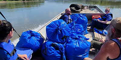 Volunteers in Boat on River Cleanup