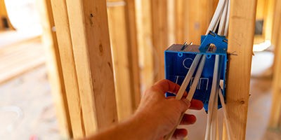 Person Installing Electrical Wires Through Outlet Box 