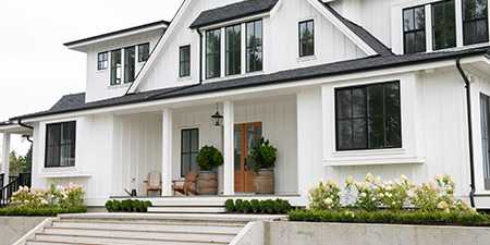 Charming Farmhouse With a Large Porch, Surrounded by Fields and Greenery.