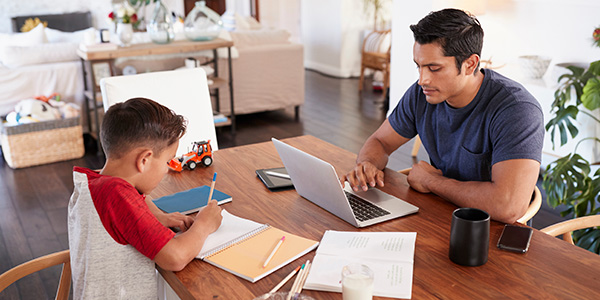 Father and Son Working at Dining Room Table