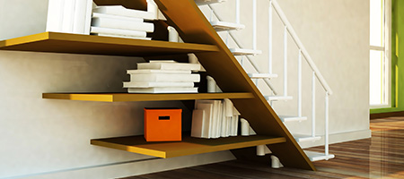 Books and Boxes Stored on Floating Shelves Built Under a Ground Floor Staircase.